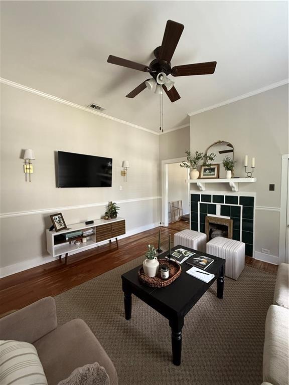 1367 Brown St, Mobile, AL 36604 - living room featuring a ceiling fan, wood finished floors, crown molding, and a fireplace