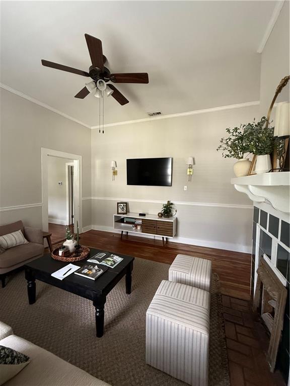 1367 Brown St, Mobile, AL 36604 - living area featuring a fireplace, ceiling fan, crown molding, and brick floors
