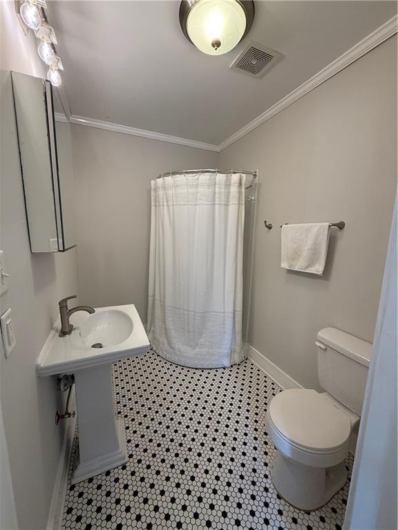 1367 Brown St, Mobile, AL 36604 - bathroom featuring ornamental molding and a shower with shower curtain