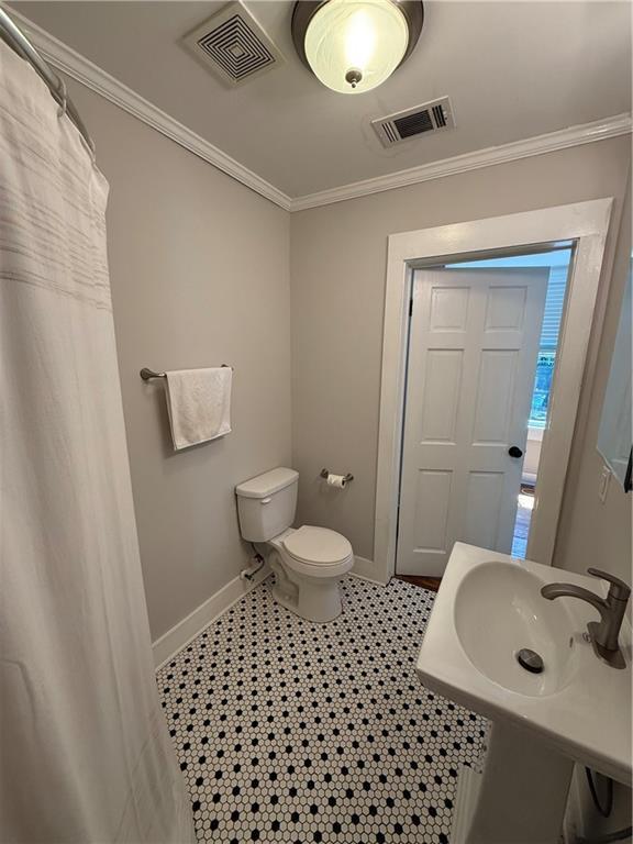 1367 Brown St, Mobile, AL 36604 - bathroom featuring ornamental molding and a shower with shower curtain