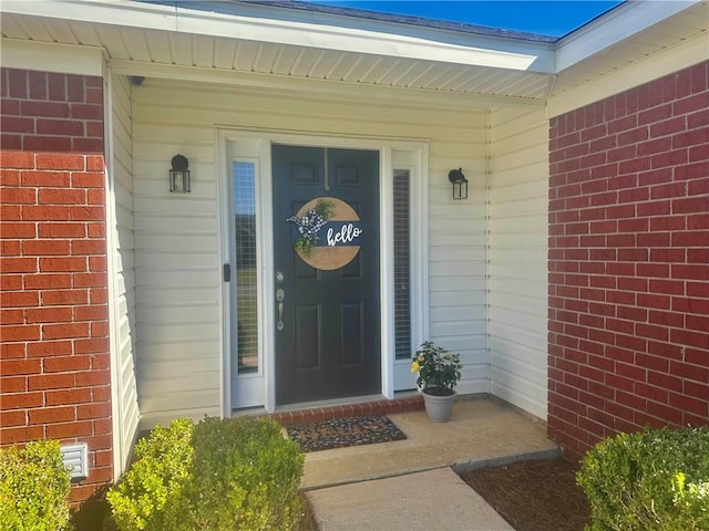 doorway to property featuring brick siding