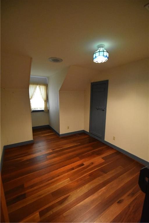 unfurnished living room with beamed ceiling, a fireplace, wood finished floors, and wooden walls