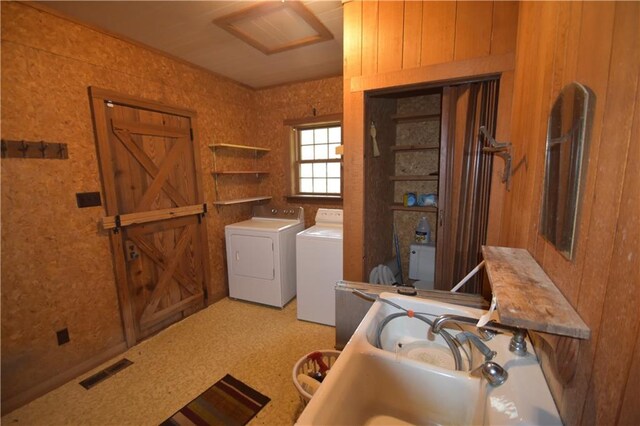 kitchen featuring double oven, wood walls, a sink, light countertops, and freestanding refrigerator