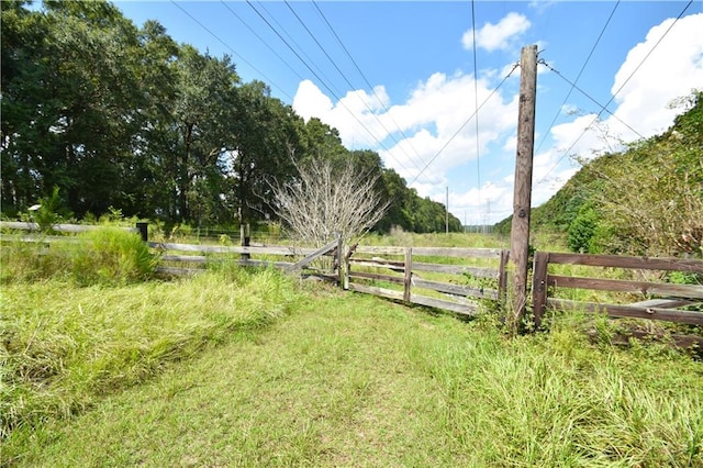 view of yard with a rural view and fence