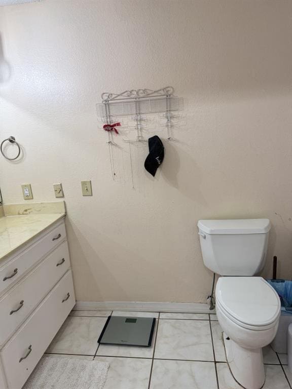 bathroom featuring tile patterned flooring, vanity, and toilet