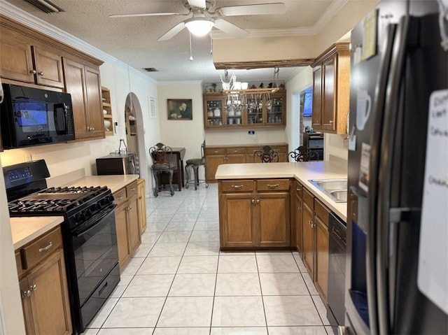 kitchen featuring kitchen peninsula, a textured ceiling, light tile patterned floors, black appliances, and ornamental molding