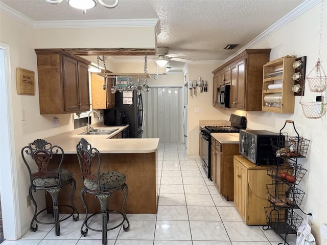 kitchen with black appliances, sink, ceiling fan, a textured ceiling, and kitchen peninsula