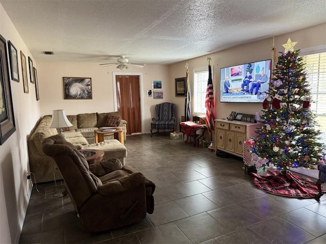 living room with ceiling fan and a textured ceiling