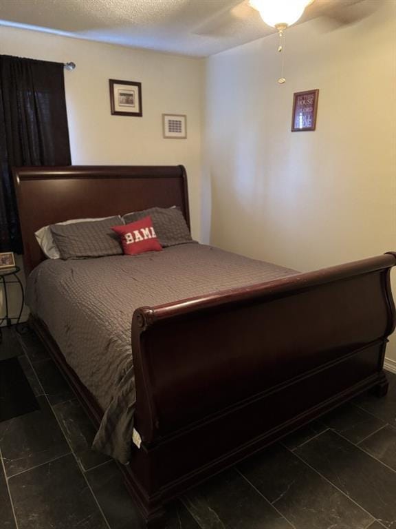 bedroom with a textured ceiling and ceiling fan