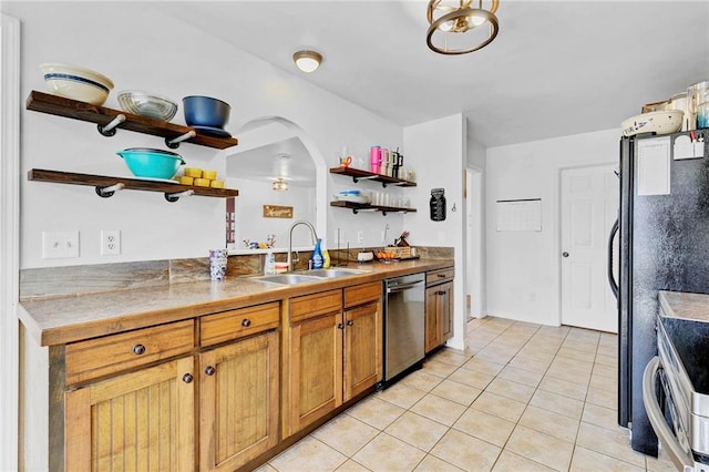 kitchen with brown cabinets, open shelves, appliances with stainless steel finishes, light tile patterned flooring, and a sink