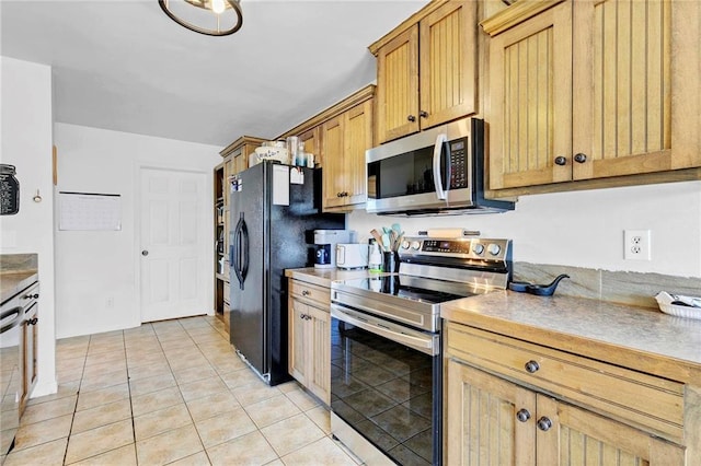 kitchen featuring light countertops, appliances with stainless steel finishes, and light tile patterned flooring