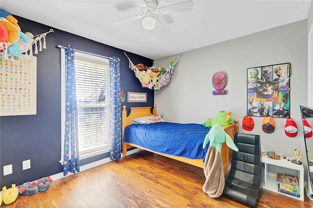 bedroom featuring ceiling fan, baseboards, and wood finished floors