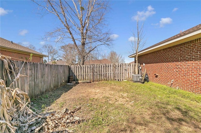 view of yard with a fenced backyard and central AC