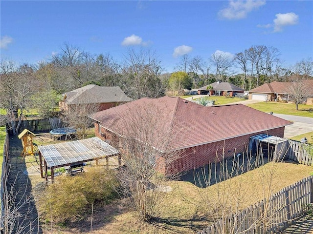 view of side of home featuring a trampoline and fence