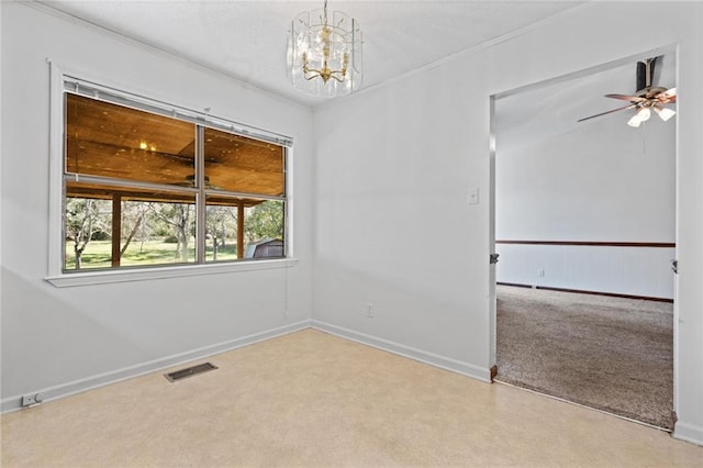 empty room with ornamental molding, visible vents, light carpet, and baseboards