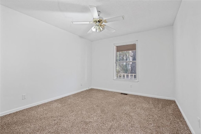 spare room with ceiling fan, carpet, visible vents, and baseboards