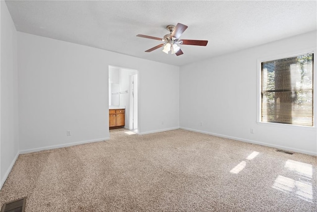 spare room with baseboards, visible vents, ceiling fan, and light colored carpet