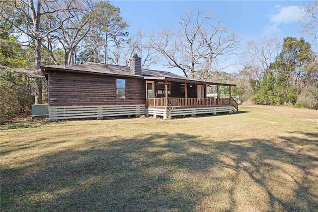 back of house featuring a deck, a yard, and a chimney