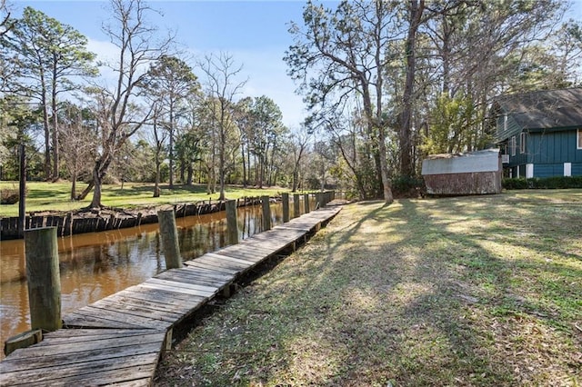 dock area with a lawn and a water view