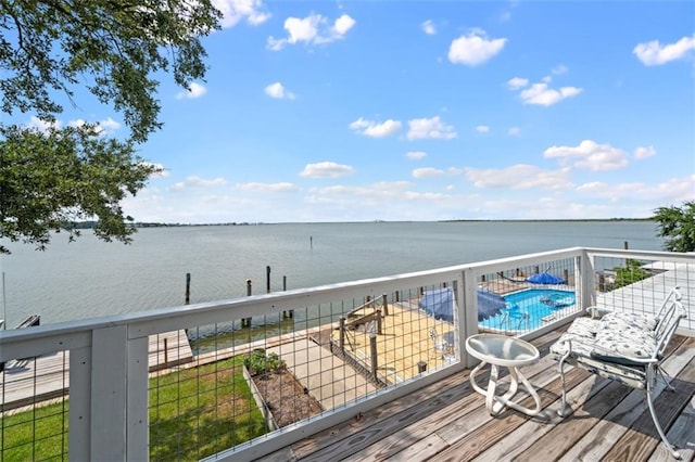 wooden deck with a water view and a community pool