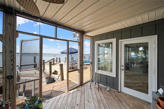 unfurnished sunroom with a water view and wood ceiling