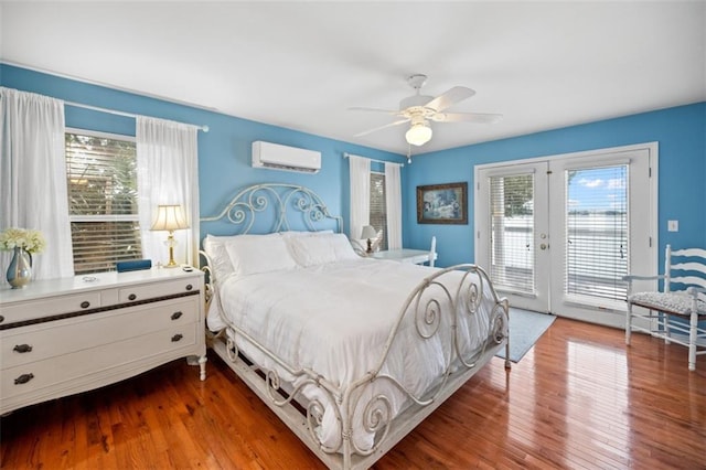 bedroom with an AC wall unit, french doors, wood-type flooring, and access to exterior