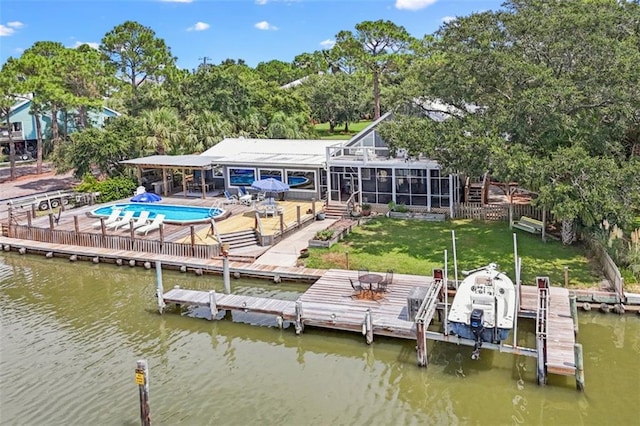 back of property featuring an outdoor pool, a lawn, a patio, boat lift, and a water view