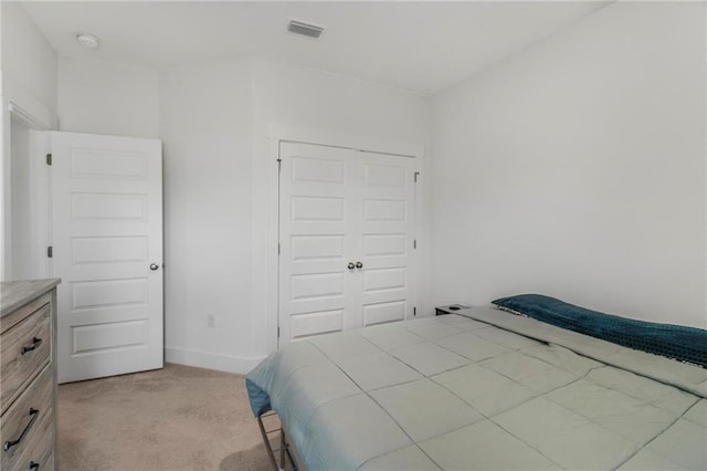 bedroom with light carpet and a closet