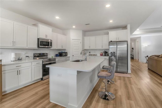 kitchen featuring tasteful backsplash, white cabinetry, sink, and appliances with stainless steel finishes