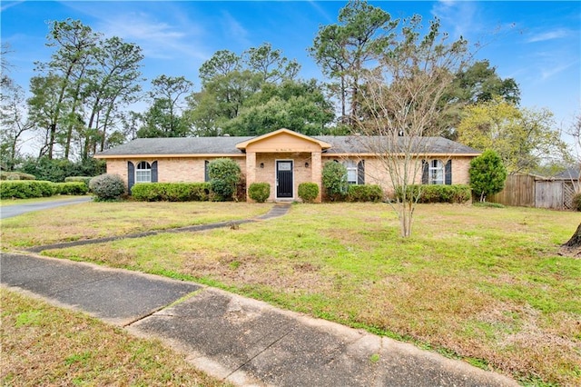 ranch-style house featuring brick siding, fence, and a front yard