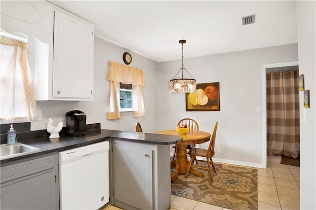 kitchen featuring visible vents, white cabinets, dark countertops, a peninsula, and white dishwasher