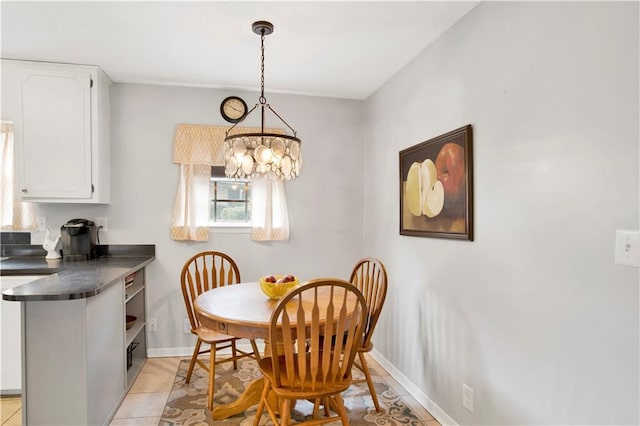 dining area featuring light tile patterned floors, baseboards, and a chandelier