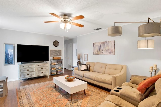 living room with visible vents, ceiling fan, a textured ceiling, and wood finished floors