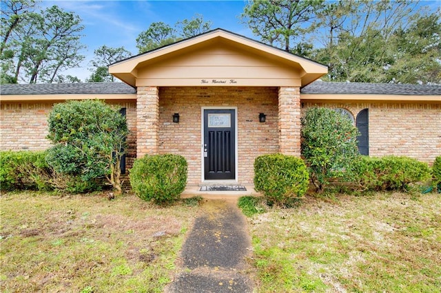 view of front of property featuring a front lawn and brick siding