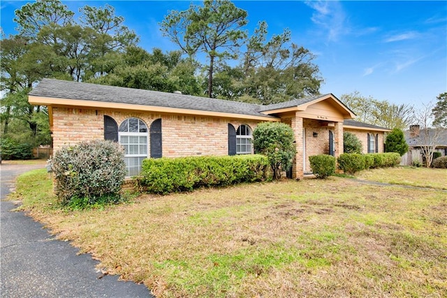 ranch-style home with a front yard and brick siding