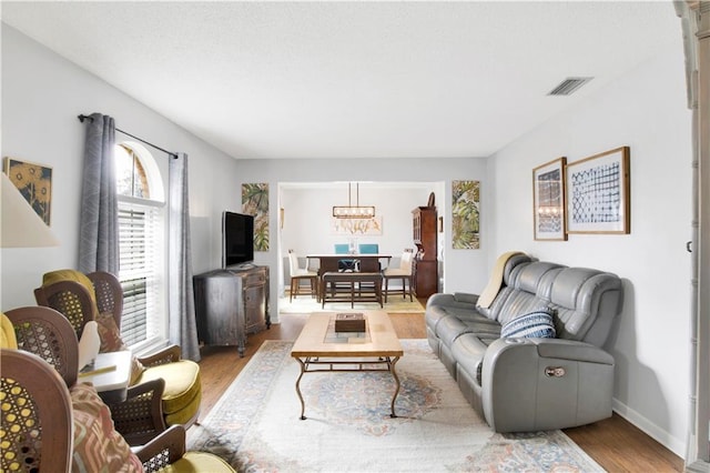 living room featuring visible vents, baseboards, and wood finished floors