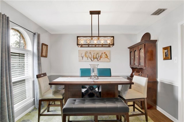 dining area featuring baseboards, visible vents, and dark wood finished floors