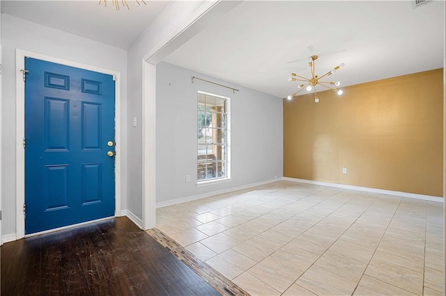 foyer entrance with light hardwood / wood-style flooring and an inviting chandelier