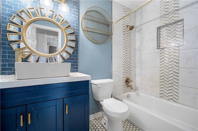 full bathroom featuring tile patterned floors, tiled shower / bath combo, toilet, and vanity