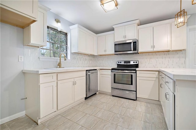 kitchen with white cabinetry, sink, decorative light fixtures, and appliances with stainless steel finishes