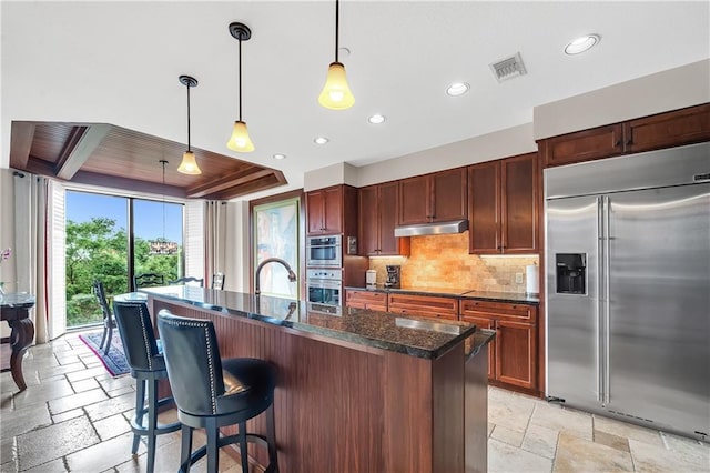 18269 Colony Dr Unit 405, Fairhope, AL 36532 - kitchen featuring stainless steel appliances, stone tile flooring, under cabinet range hood, backsplash, and recessed lighting