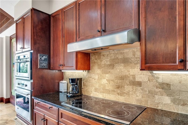 18269 Colony Dr Unit 405, Fairhope, AL 36532 - kitchen featuring under cabinet range hood, oven, black electric cooktop, light stone finish floors, and backsplash