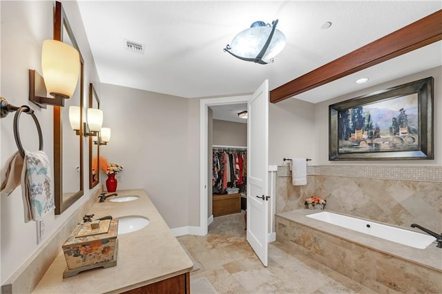 18269 Colony Dr Unit 405, Fairhope, AL 36532 - full bath with double vanity, a bath, a walk in closet, and baseboards