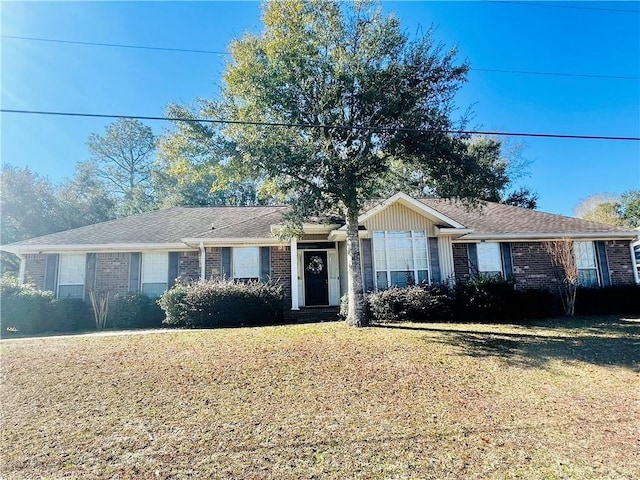 ranch-style home featuring brick siding and a front lawn