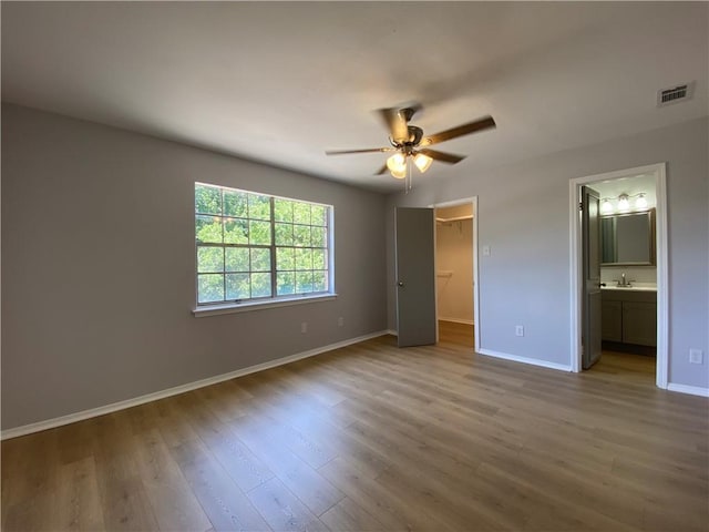 112 Du Rhu Dr Unit 112-H, Mobile, AL 36608 - unfurnished bedroom featuring baseboards, wood finished floors, a walk in closet, a closet, and ensuite bathroom