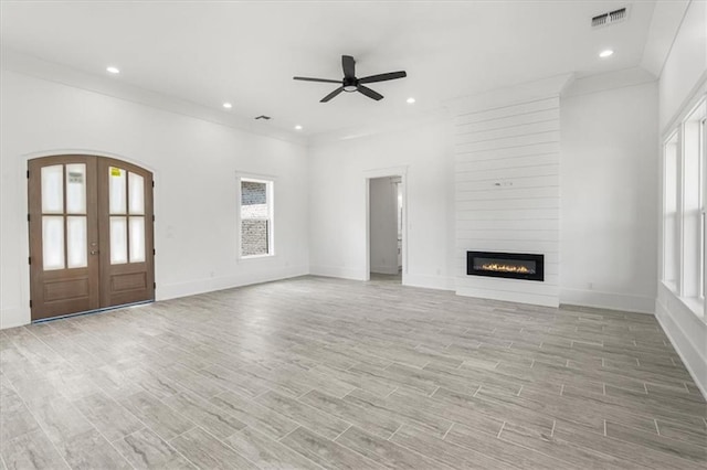 unfurnished living room with ceiling fan, light hardwood / wood-style floors, a healthy amount of sunlight, and a fireplace