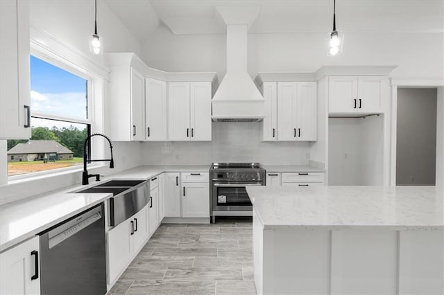 kitchen featuring appliances with stainless steel finishes, white cabinetry, premium range hood, and tasteful backsplash