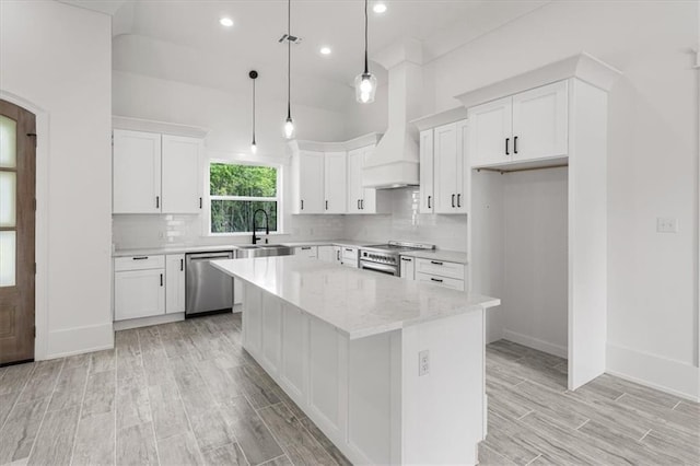 kitchen featuring stainless steel appliances, white cabinets, backsplash, and pendant lighting