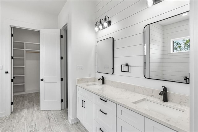 bathroom with double sink vanity, hardwood / wood-style flooring, and wooden walls