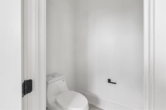 bathroom featuring tile flooring and toilet